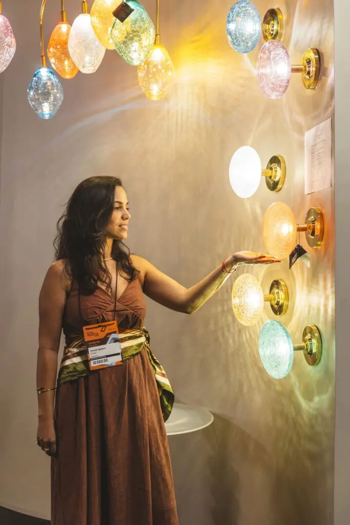 Woman admiring colorful glowing orbs on a wall.