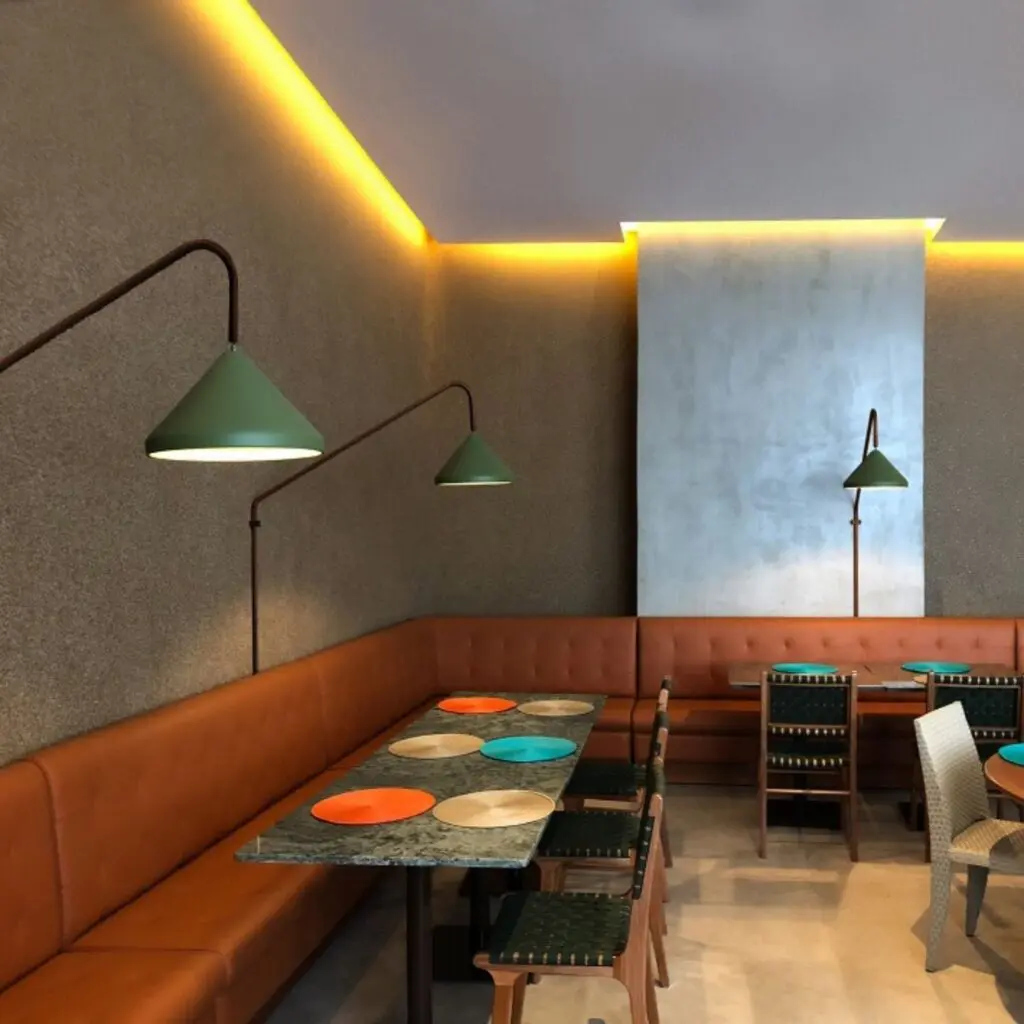 Cozy cafe interior with warm lighting and colorful tables.