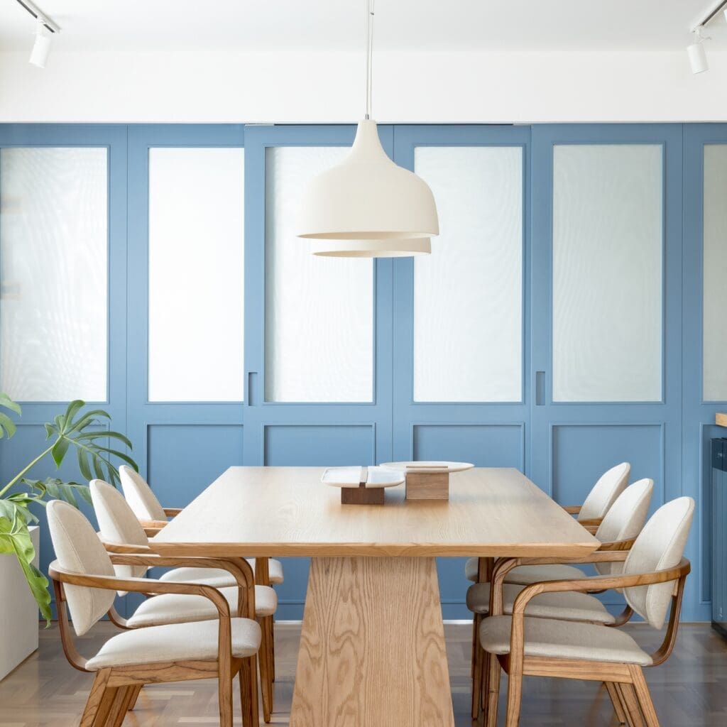 Modern dining room with wooden table and chairs under a pendant light.